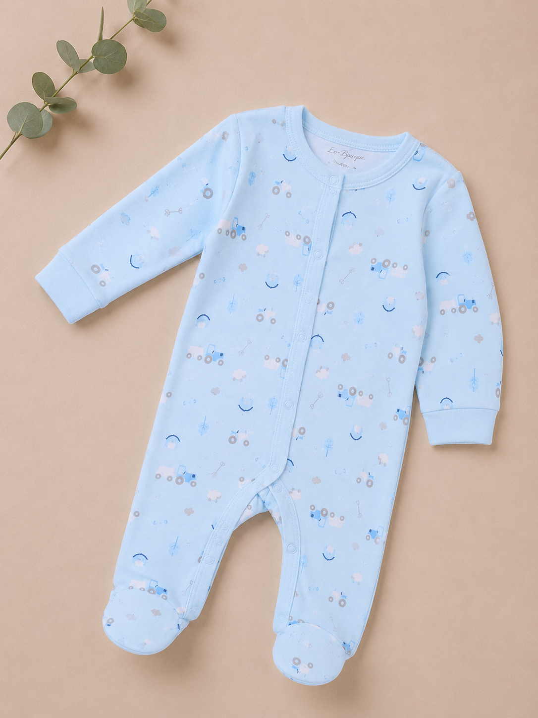Blue baby onesie with patterns on a beige background
