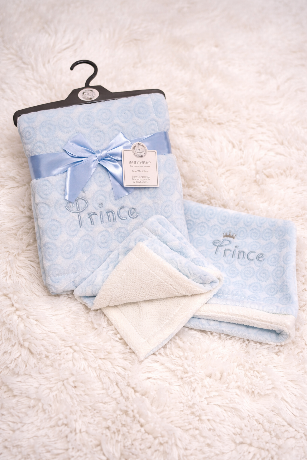 A beautifully textured swirl cable knit baby blanket with a soft sherpa reverse, designed for warmth and comfort. Perfect for prams, home use, and thoughtful newborn gifts.