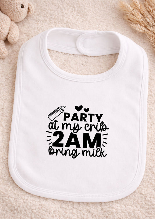 White baby bib with humorous text design on a soft surface