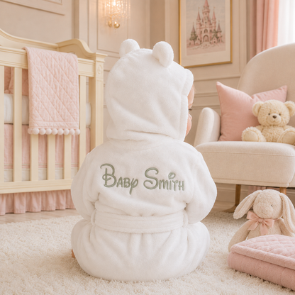 White baby robe with 'Baby Smith' embroidered on it in a nursery setting.