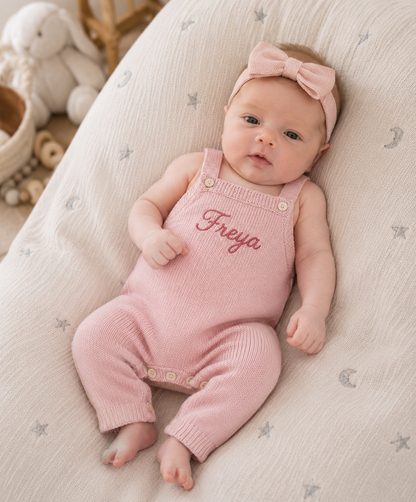 Personalised pink knitted baby dungarees with name Freya embroidered on the front bib