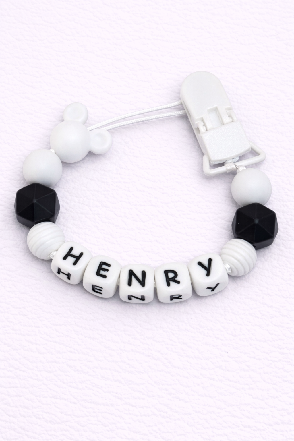 dummy clip with letter beads spelling 'HENRY' on a white background