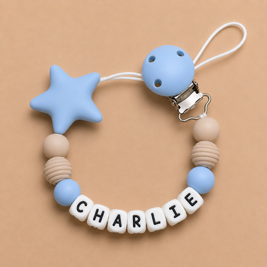 Baby dummy clip with star and round blue beads on a beige background