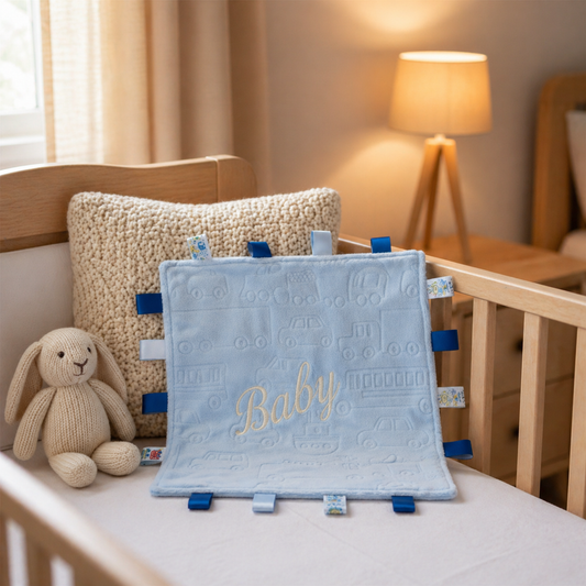 Baby blanket with 'Baby' embroidery on a crib in a nursery setting