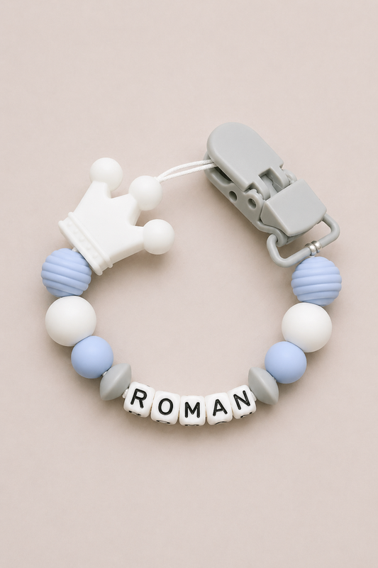 Teething ring with colorful beads and a clip on a beige background