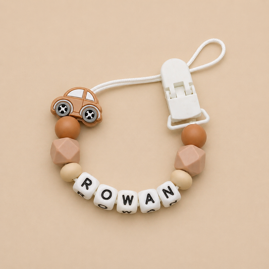 dummy clip with colorful beads and a car-shaped clip on a beige background