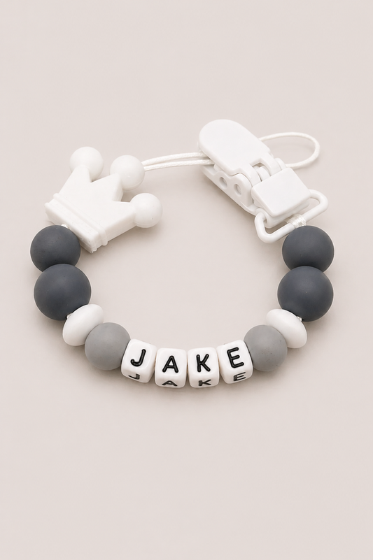 Bracelet with letter beads spelling 'JAKE' on a beige background