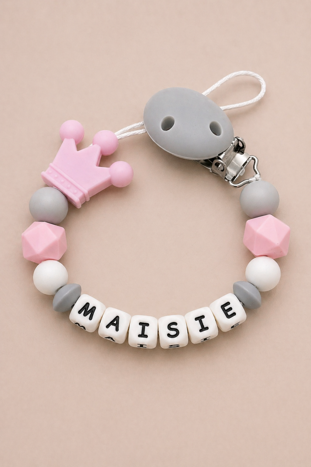 Teething bracelet with 'MAISIE' beads on a beige background