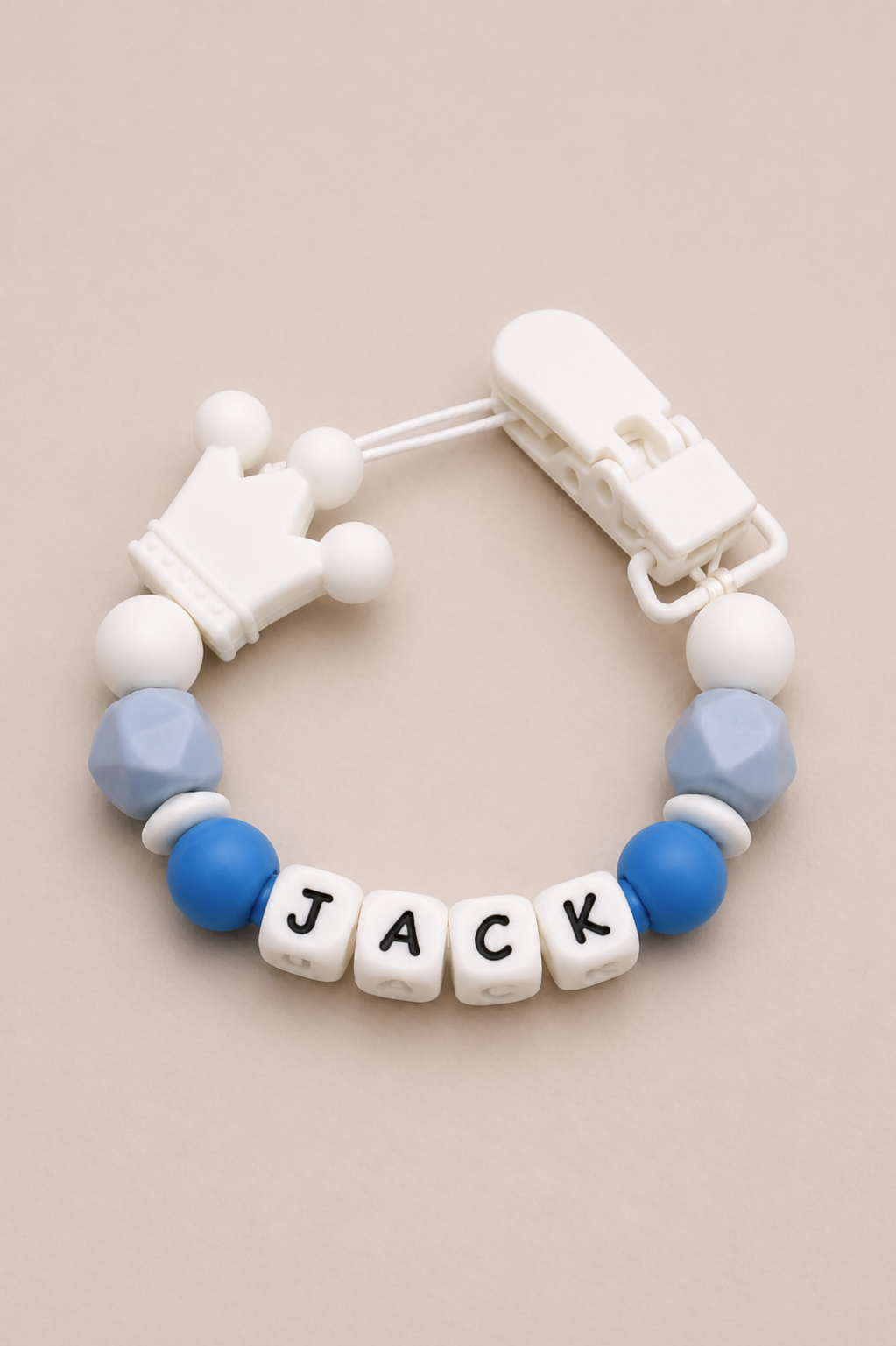 Baby teether with 'JACK' beads on a beige background