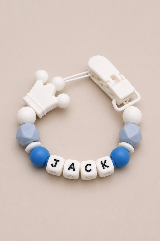 Baby teether with 'JACK' beads on a beige background