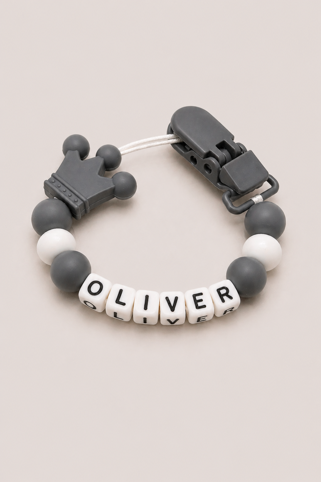 Bracelet with letter beads spelling 'OLIVER' on a beige background