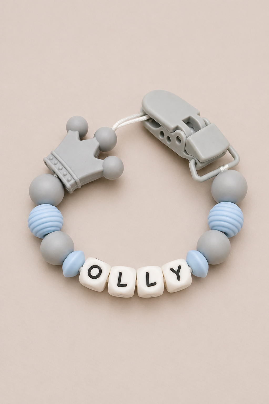 Teething bracelet with 'OLLY' beads on a beige background