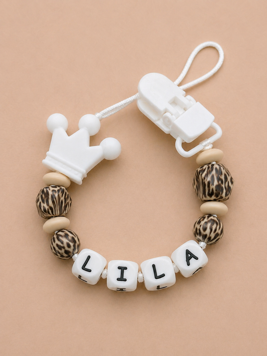 Teething bracelet with leopard print beads and a crown charm on a beige background