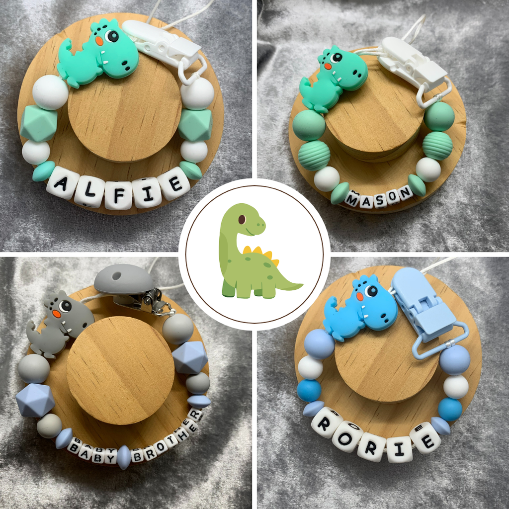 Handcrafted personalised dinosaur dummy clip for babies, made with food-grade silicone beads, metal clasp, and optional MAM adapter, suitable for newborns and infants