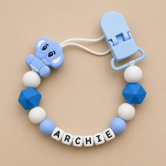 dummy clip with blue and white beads and a clip on a beige background