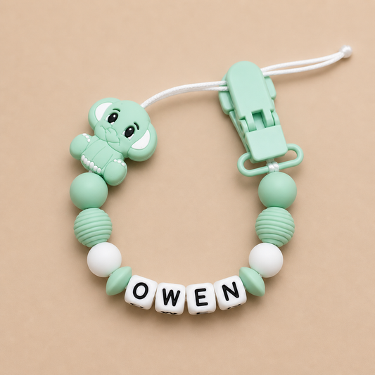 Mint green dummy clip with 'OWEN' letters on a beige background