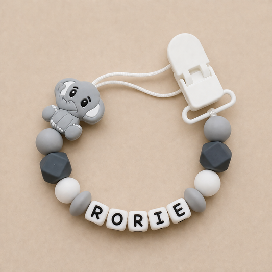 dummy clip with elephant design and 'RORIE' beads on a beige background