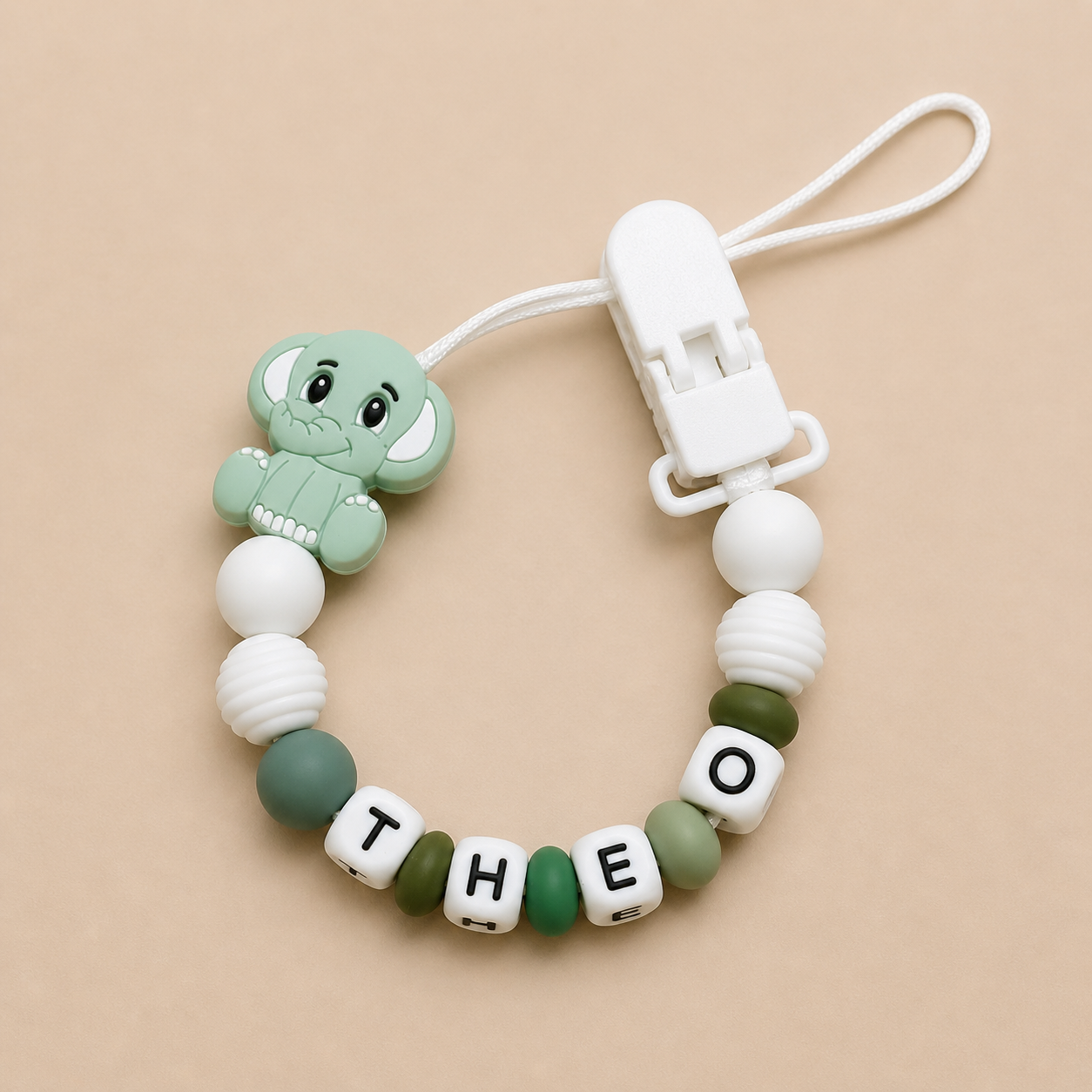 tdummy clipwith elephant charm and personalized name on beige background