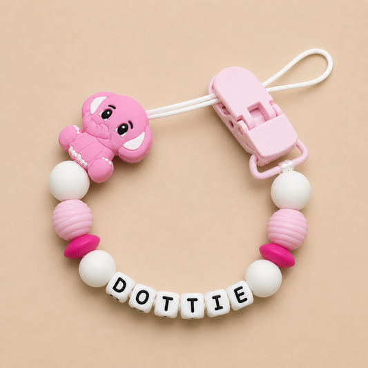 Pink and white baby dummy clip with 'DOTTIE' on a beige background