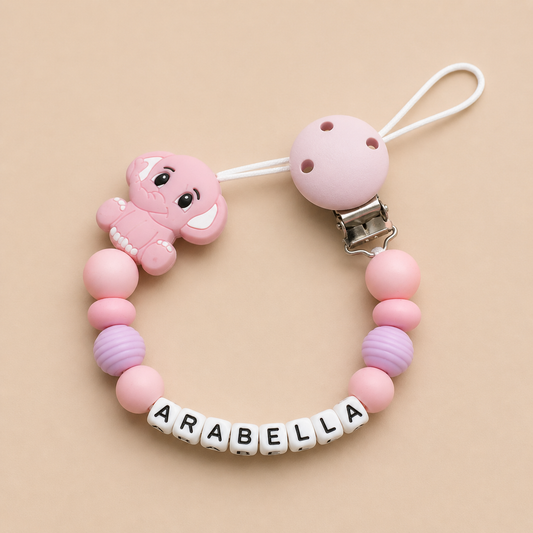Pink dummy clip with a character and 'ARABELLA' name on a beige background