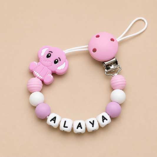 Pink baby teether with 'ALAYA' on a beige background