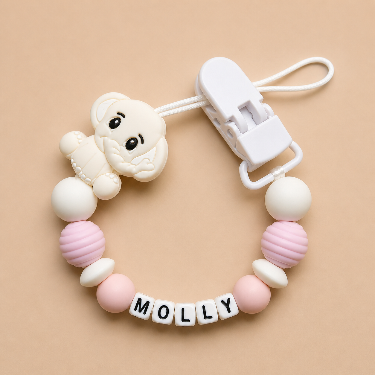 dummy clip with pink and white beads and a clip on a beige background