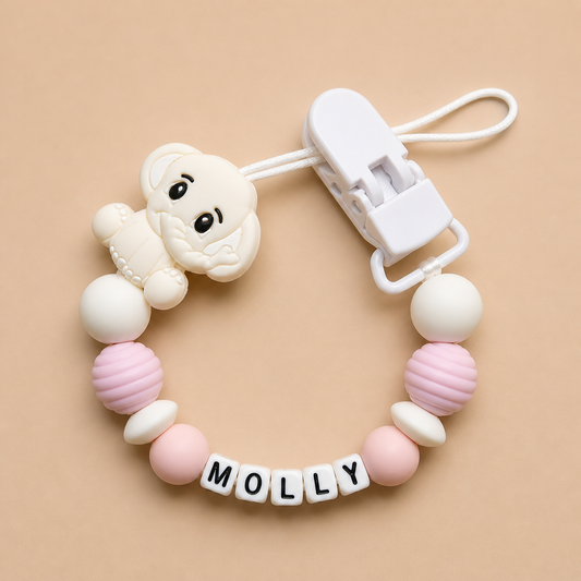 dummy clip with pink and white beads and a clip on a beige background