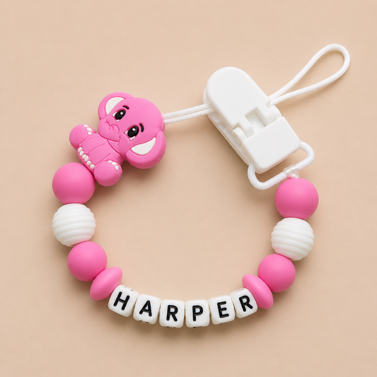 Pink and white dummy clip with a clip on a beige background