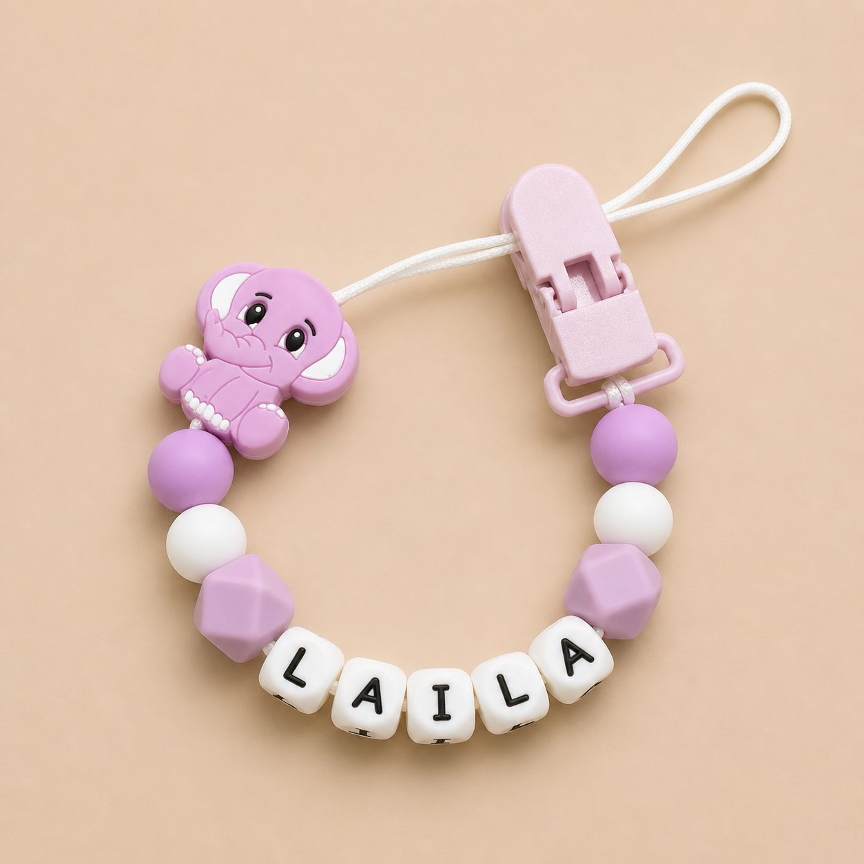 Purple elephant dummy clip with 'LAILA' on a beige background