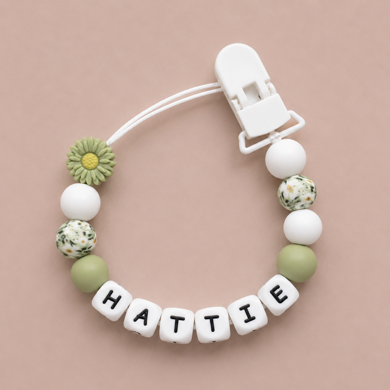 dummy clip with 'HATTIE' beads on a beige background