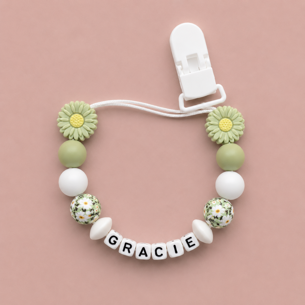 Baby dummy clip with floral beads and 'GRACIE' clip on a pink background