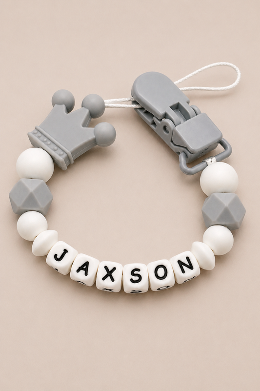Baby teether with 'JAXSON' name on beads against a beige background