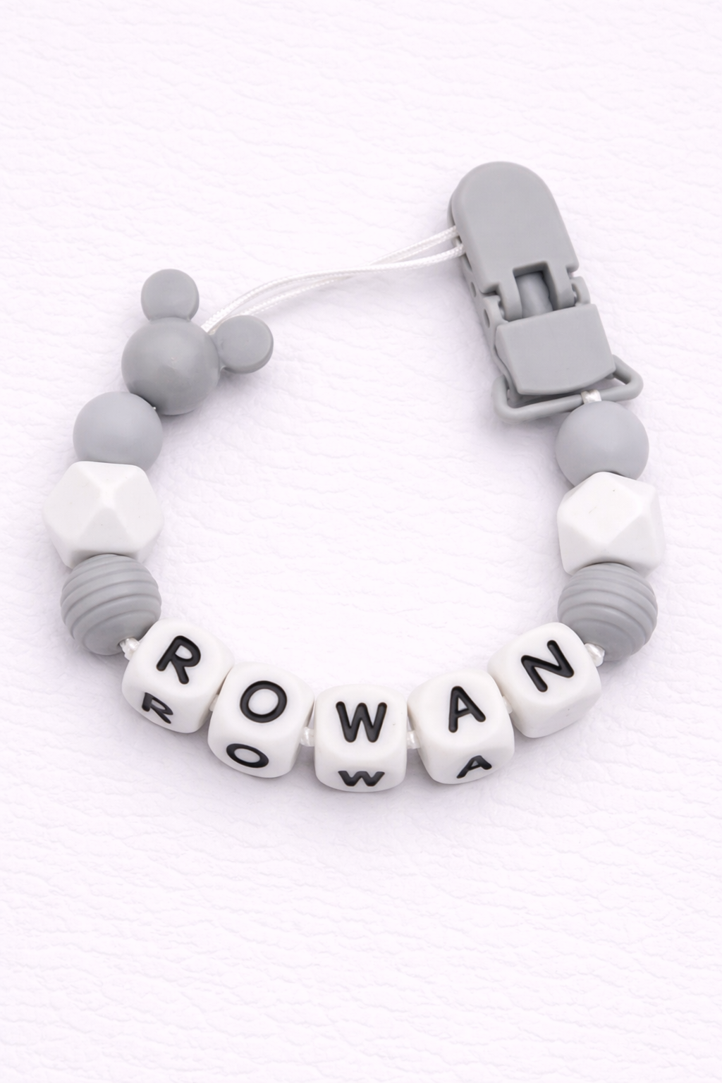 Gray and white dummy clip with 'ROWAN' on a white background