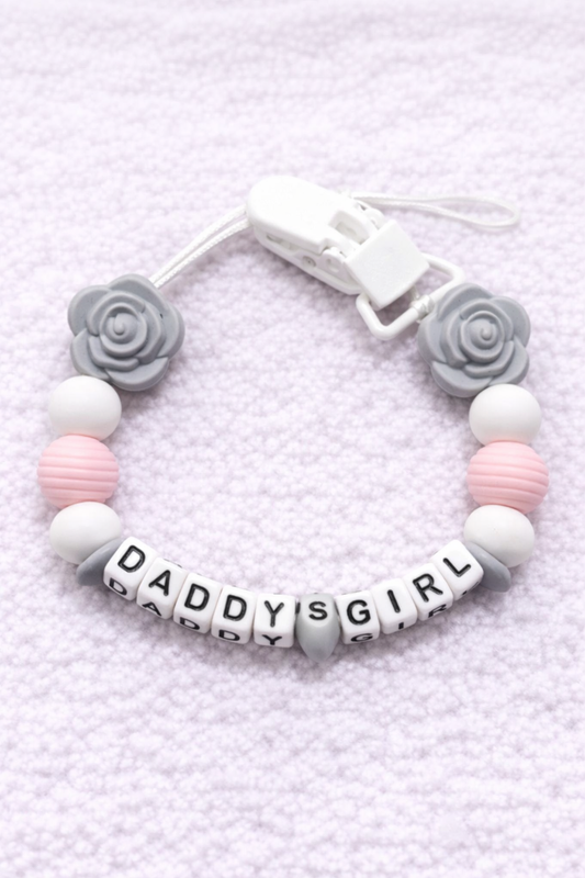 dummy chain with 'DADDY'S GIRL' beads on a textured light purple background