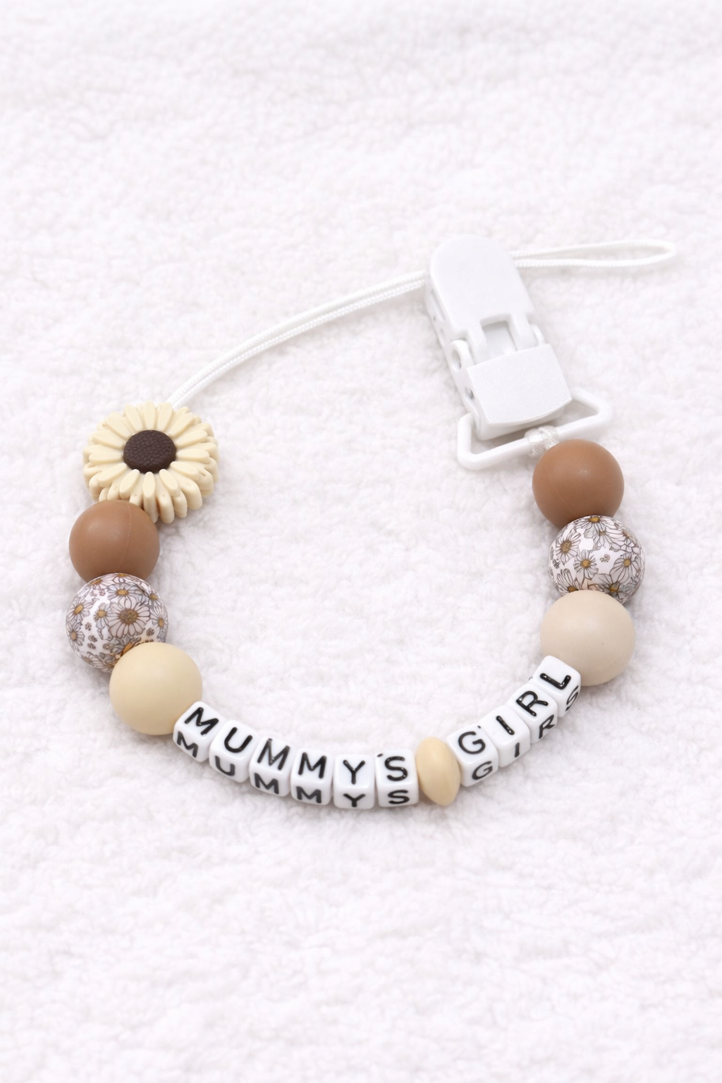 dummy clip with wooden beads and 'MUMMY'S GIRL' tag on a white background