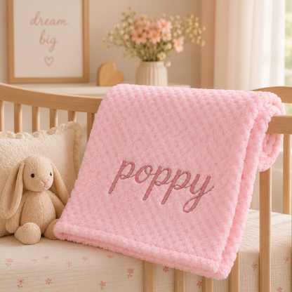 Soft Pink bubble baby blanket embroidered with "Poppy" in Rose Gold, beautifully styled over a wooden crib in a neutral nursery. A thoughtful keepsake gift for a new baby, baby shower or Nana.