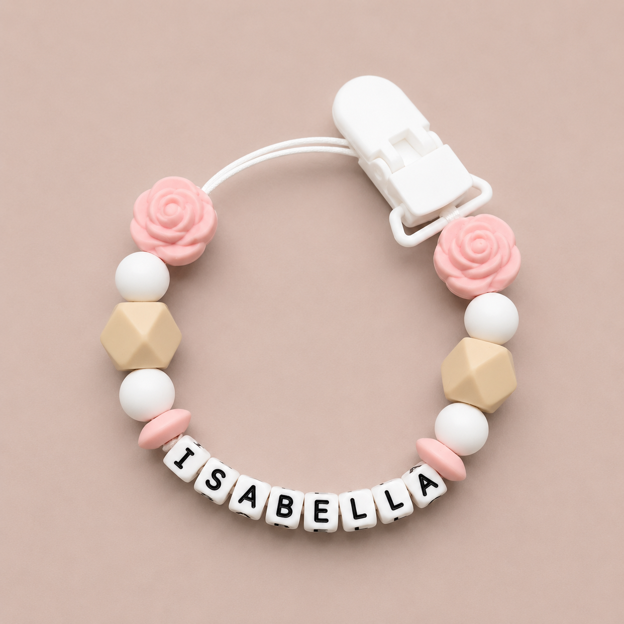 Baby dummy clipt c with geometric beads and pink flowers on a beige back