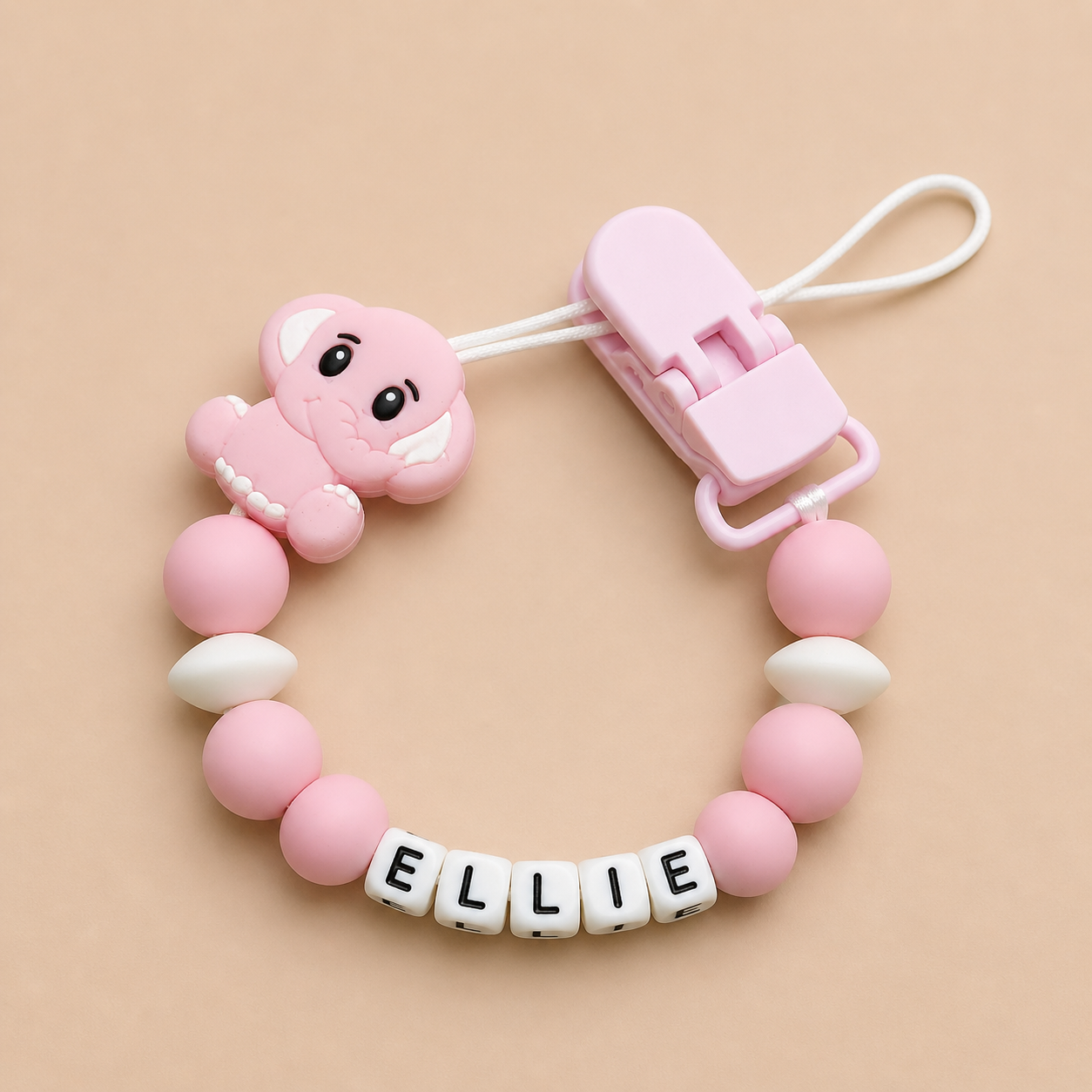 Pink and white dummy clip with a clip on a beige background
