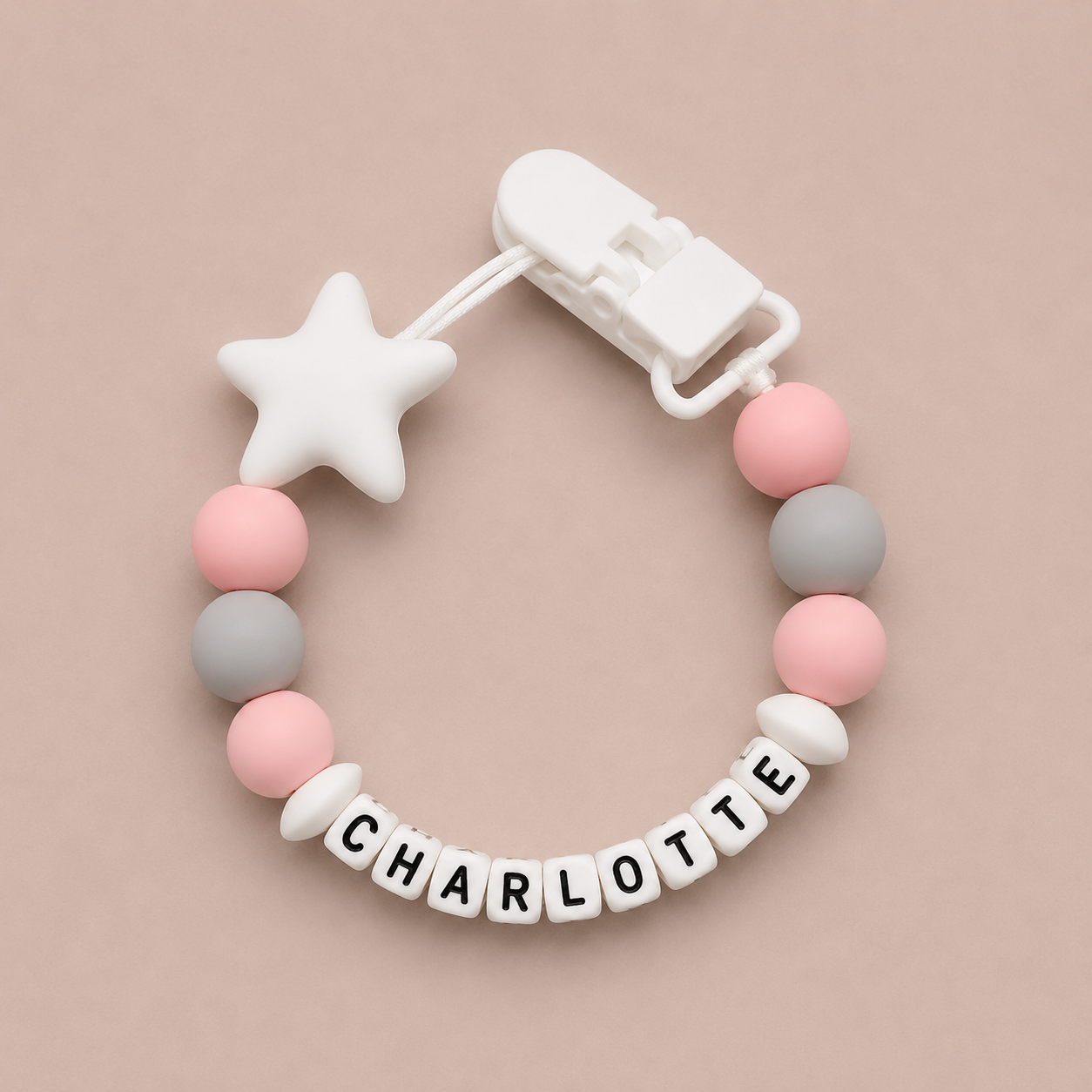 Baby dummy clip with pink and gray beads and a star-shaped clip on a beige background