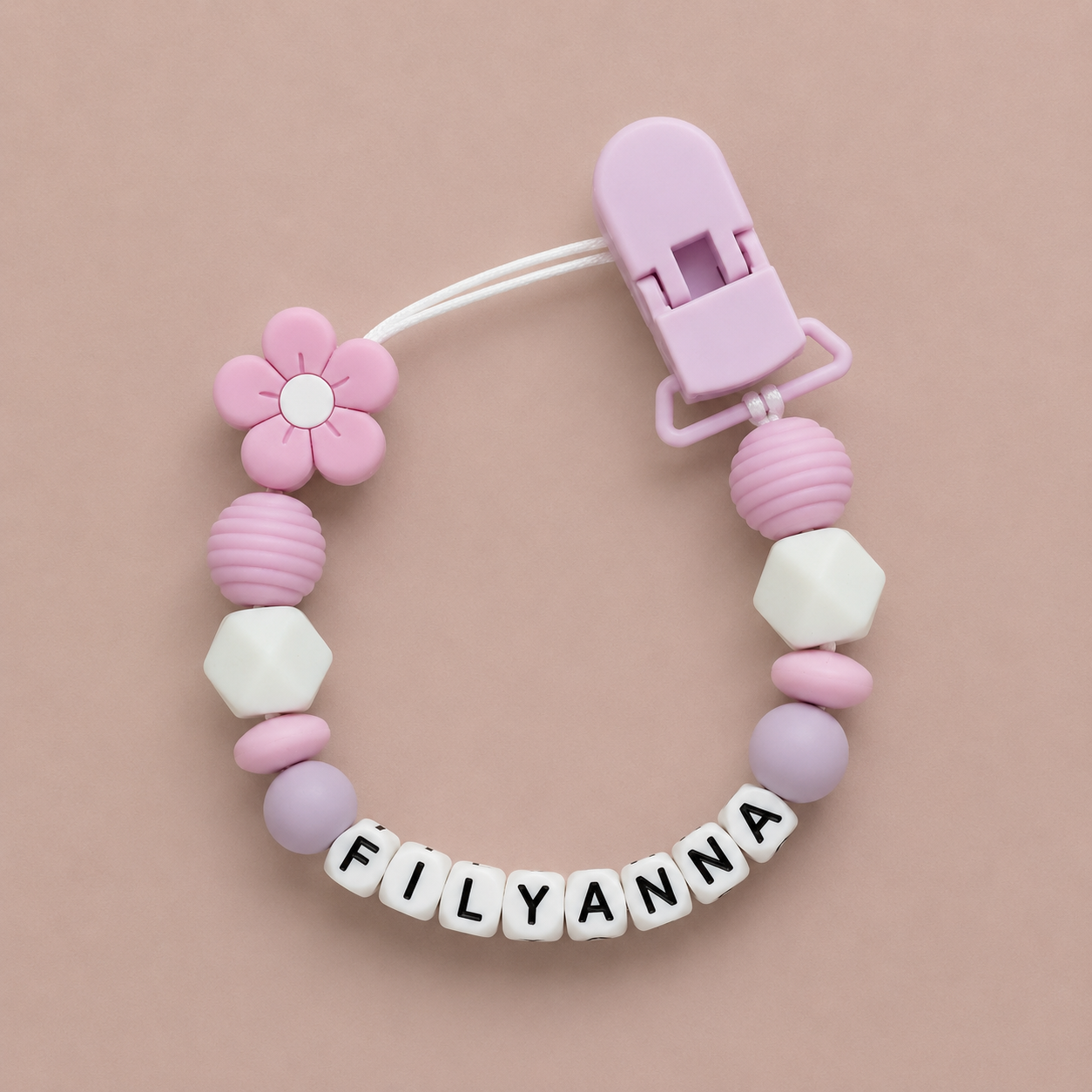 Baby dummy clip with colorful beads and a clip on a beige background