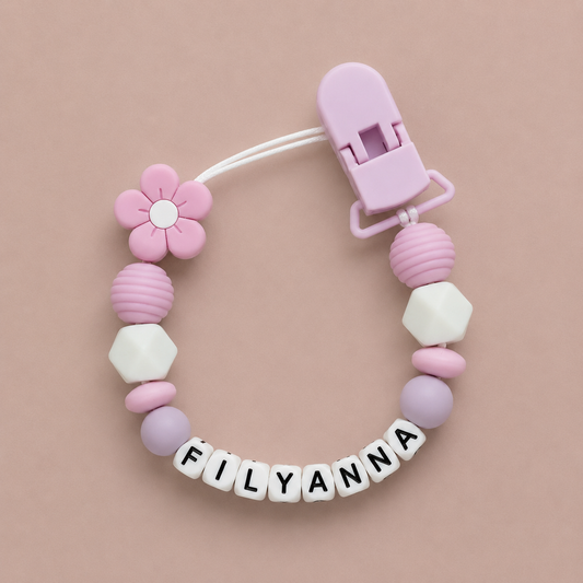 Baby dummy clip with colorful beads and a clip on a beige background