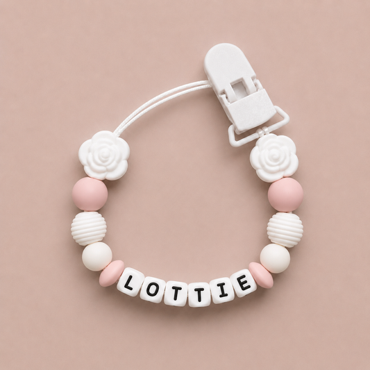 Baby dummy clip with 'LOTTIE' on a beige background