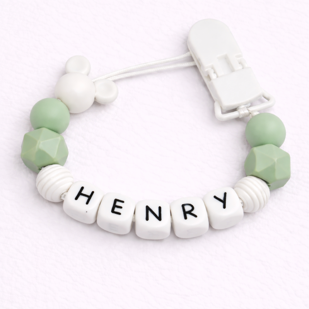 dummy clip with green beads and 'HENRY' on a white background