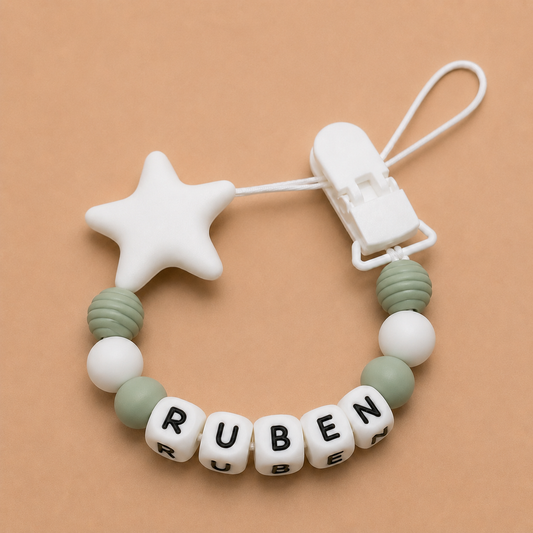 dummy clip with star-shaped chewable and letter beads spelling 'RUBEN' on a beige background