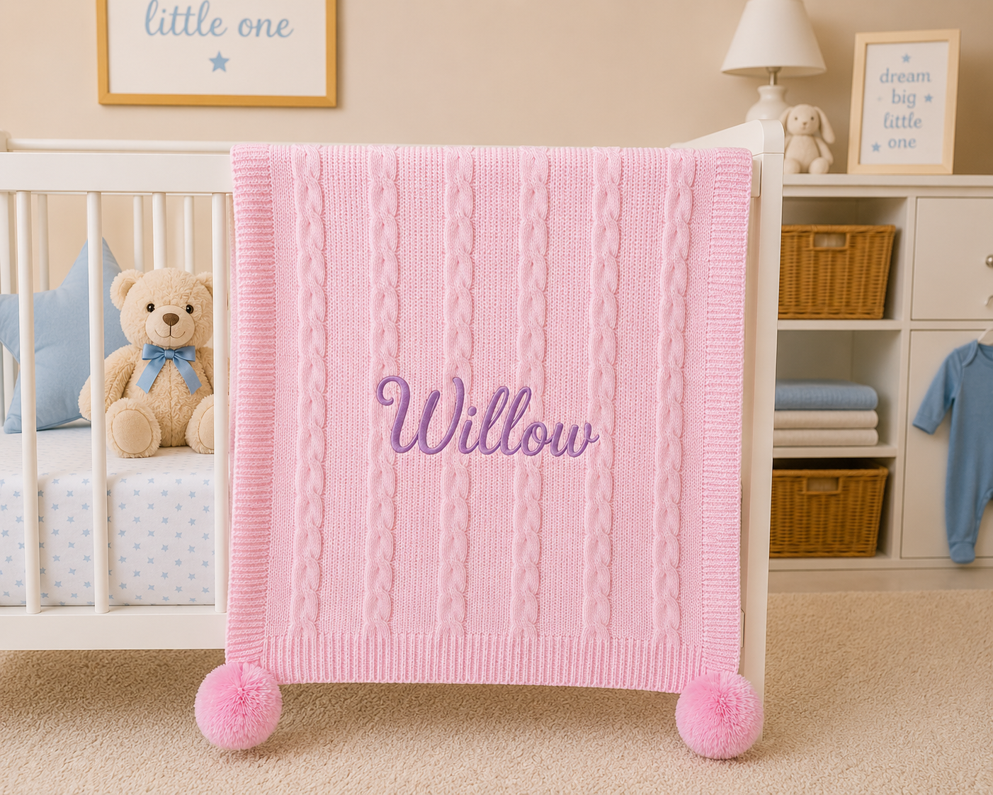 Pink baby blanket with 'Willow' embroidered on it in a nursery setting.