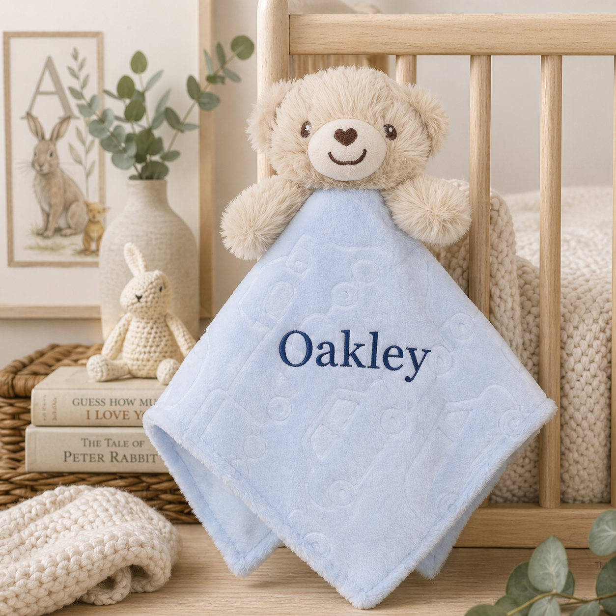 Baby comfort blanket with teddy bear and name 'Oakley' in a nursery setting