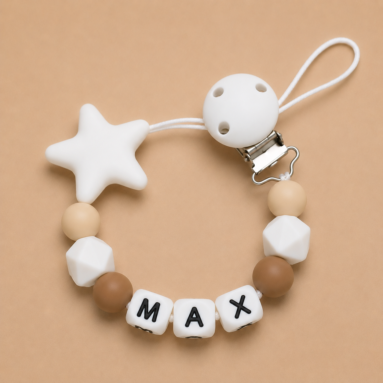 dummy clip with star, cube, and round beads on a beige background