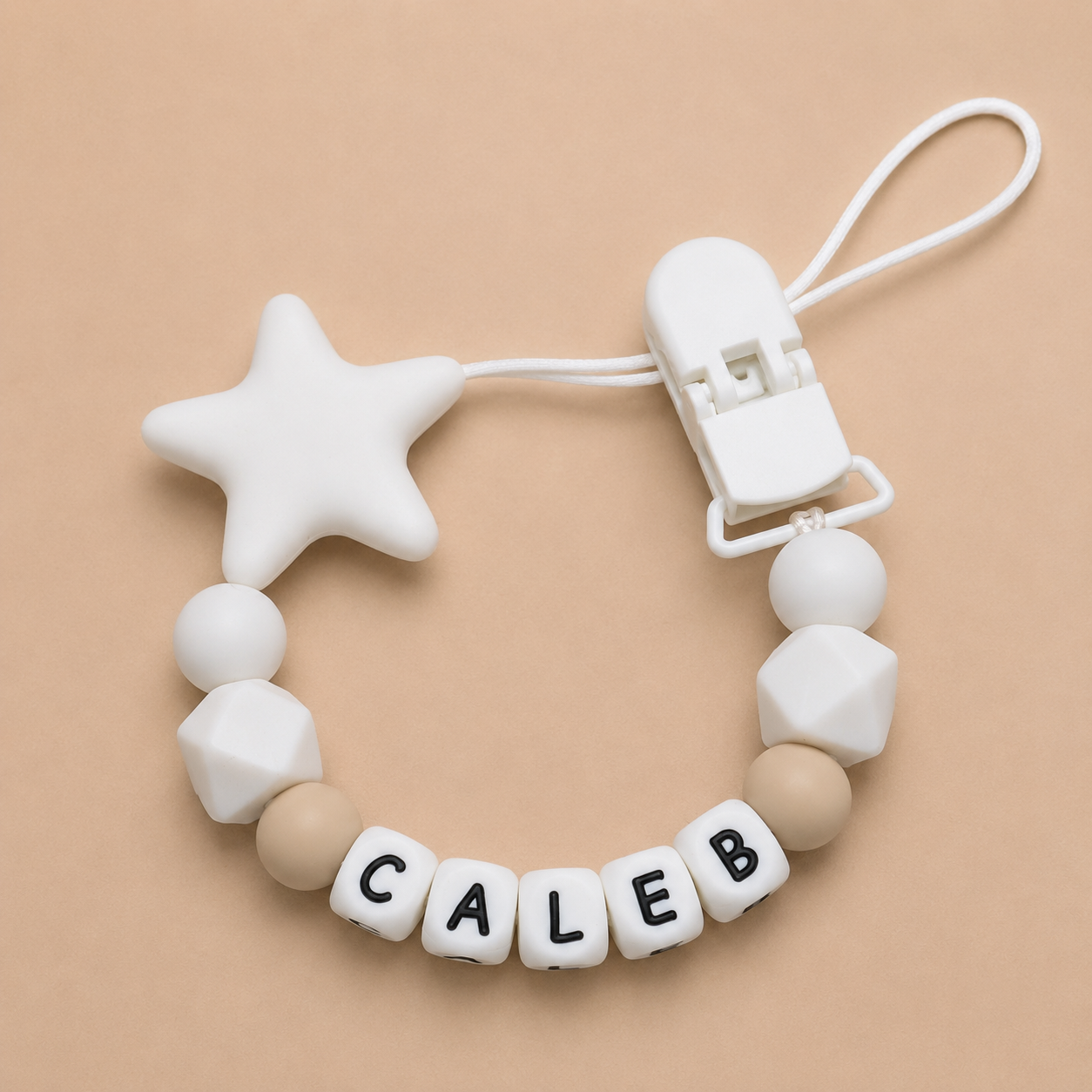 White and beige dummy clip with 'CALEB' letters on a beige background