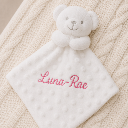 White teddy bear security blanket with 'Luna-Rae' embroidered on a textured beige surface