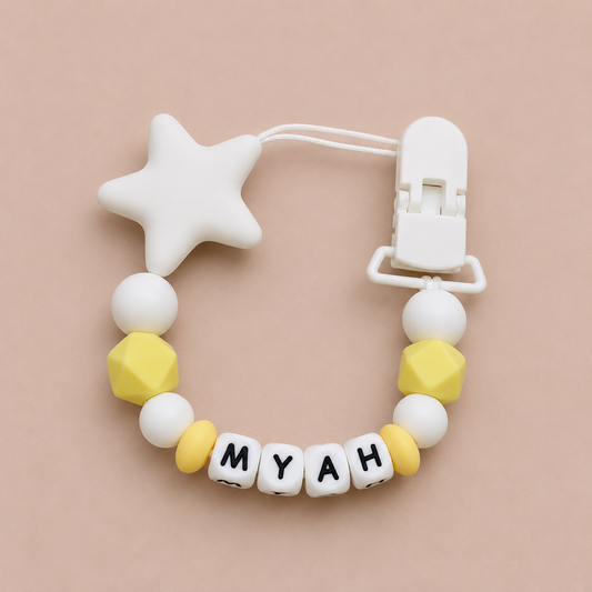 dummy clip with star-shaped clip and 'MYAH' beads on a beige background